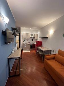 un soggiorno con divano e tavolo e una cucina di Bilocale Voltri Mare 4 posti a Genova