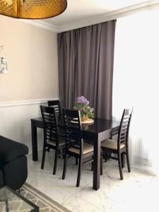 a dining room with a black table and chairs at Apartament Alicja in Sztutowo