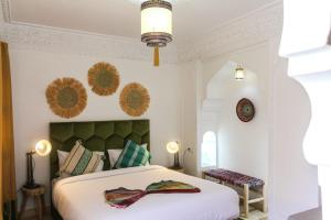 a bedroom with a bed and a clock on the wall at RIAD KECHMARA in Marrakesh
