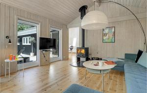 SnogebækにあるAwesome Home In Nex With Saunaのリビングルーム(青いソファ、暖炉付)