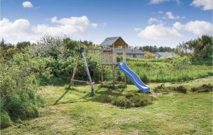 a playground in a field with a slide at Nice Home In Ringkbing With 6 Bedrooms, Wifi And Indoor Swimming Pool in Søndervig