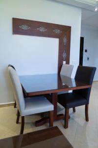 einen Holztisch mit zwei weißen Stühlen und einem Schreibtisch in der Unterkunft Résidence hôtelière & Resort - Moroccan Floors in Tangier