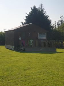 ein kleines Haus auf einem grünen Rasen in der Unterkunft Le Chal Adret in Cardonville