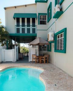 uma casa com piscina em frente a um edifício em Turtle Bay Inn em Lajas