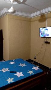 Un dormitorio con una cama azul con estrellas. en STUDIO 2 Climatisé et Ventilateur Plafonnier et WIFI GRATUIT A 6 NUITEES DE RESERVATION en Lomé