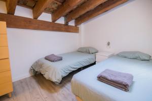 two beds in a room with wooden ceilings at Cozy Duplex Apartment 1 step to City Center SelfCheckin! in Valencia