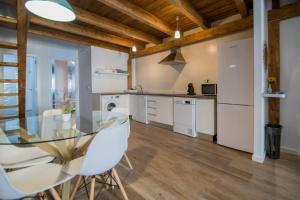 a kitchen with a glass table and white appliances at Cozy Duplex Apartment 1 step to City Center SelfCheckin! in Valencia