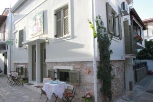 a white building with a table in front of it at Orpheus and Eurydice Boutique Apartments in Skiathos