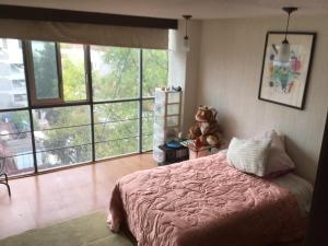 een slaapkamer met een bed met een teddybeer op een tafel bij Angel,s apartment in Mexico-Stad
