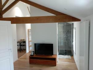 a living room with a flat screen tv on a wooden table at Chambre d'hôtes dans maison charentaise in Mortiers