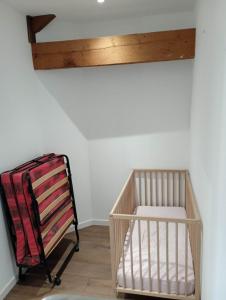 ein Kinderbett in einem Zimmer mit Holzdecke in der Unterkunft Chambre d'hôtes dans maison charentaise in Mortiers