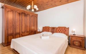 1 dormitorio con 1 cama grande y cabecero de madera en Cozy Apartment In Lovran With Wifi, en Lovran