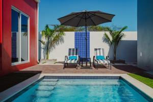 een zwembad met 2 stoelen en een parasol bij Trankilidad Apartments in Santa Cruz