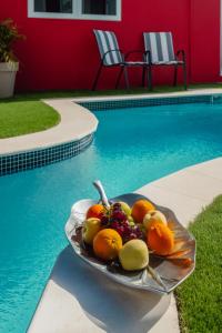 a plate of fruit sitting next to a swimming pool at Trankilidad Apartments in Santa Cruz