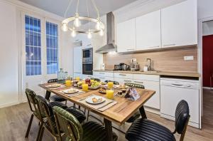 a kitchen with a wooden table and chairs at Sweet Inn - La Pedrera - Paseo de Gracia in Barcelona