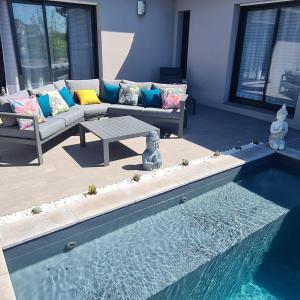 a living room with a couch and a swimming pool at Villa- suite privée avec accès sur piscine in Villebrumier