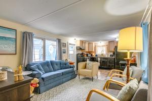 ein Wohnzimmer mit einem blauen Sofa und einer Küche in der Unterkunft Pet-Friendly Caseville Cottage Walk to Lake Huron in Caseville