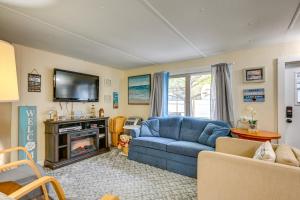 ein Wohnzimmer mit einem blauen Sofa und einem TV in der Unterkunft Pet-Friendly Caseville Cottage Walk to Lake Huron in Caseville