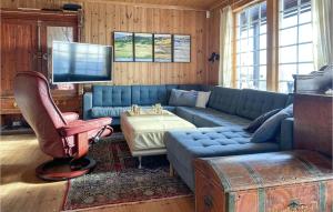 een woonkamer met een blauwe bank en een flatscreen-tv bij Awesome Home In Ingeberg With Kitchen in Syljuset