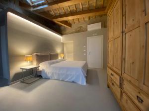 1 dormitorio con cama blanca y armario de madera en Piccola Dimora Gherardini, en SantʼElpidio a Mare
