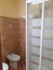 a bathroom with a toilet and a sink and a shower at Apartamentos Isabel in Maro