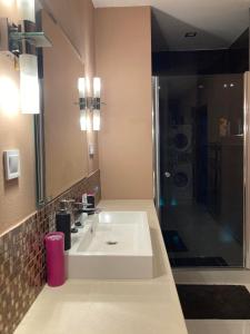 a bathroom with a white sink and a shower at Dovolenkový dom eLAra in Smižany