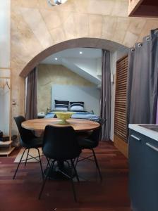 een eetkamer met een tafel en stoelen en een bed bij Mini Loft 4 P, centre historique in Bordeaux