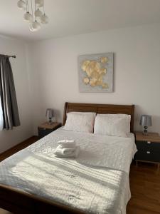 a bedroom with a white bed with two night stands at Apartment la mare in Agigea