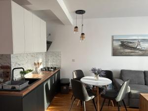 a kitchen with a table and chairs and a couch at Apartment la mare in Agigea