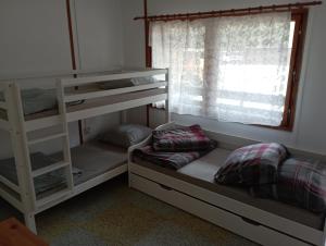 a room with two bunk beds and a window at Chatka Andělka in Doksy