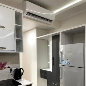 a kitchen with white cabinets and a refrigerator at Angel Apartment in Porta Batumi in Batumi