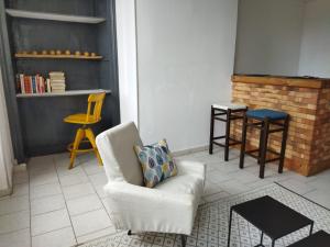a living room with a chair and a table at Le Chapitre in Châteaumeillant