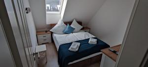 a small bedroom with a bed with blue sheets and pillows at Koje 4 in Graal-Müritz
