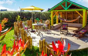 eine Holzterrasse mit einem Tisch, Stühlen und einem Sonnenschirm in der Unterkunft Nice Home In Plouguerneau With Wifi in Plouguerneau