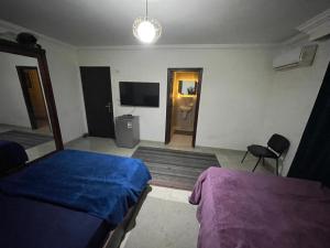 a bedroom with two beds and a flat screen tv at ڤيلا فاخره في مدينة طنطا in Tanta