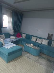 ein Wohnzimmer mit einem blauen Sofa und Tischen in der Unterkunft ڤيلا فاخره في مدينة طنطا in Tanta