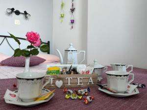 a table with two tea cups and a vase with a flower at Porto Haraki Studios in Haraki