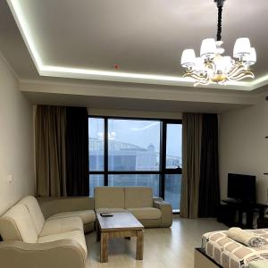 a living room with a couch and a large window at Angel Apartment in Porta Batumi in Batumi