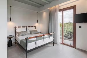 a bedroom with a bed and a balcony at Villa Nineta in Tavronitis