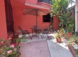 a patio with a table and chairs and an umbrella at Casa Rosa in Tepotzotlán