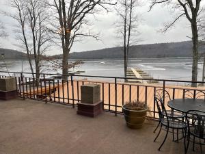 a balcony with tables and chairs and a view of a lake at Beautiful Lake Harmony Townhouse with views of Big Boulder Lake in Lake Harmony