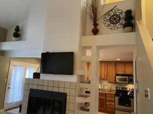 a kitchen with a fireplace and a tv on the wall at Beautiful Lake Harmony Townhouse with views of Big Boulder Lake in Lake Harmony