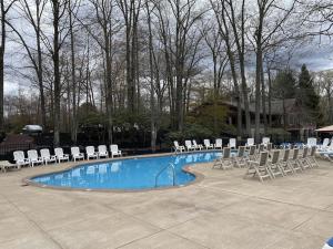 ein Pool mit Liegestühlen und ein paar Liegenschaften in der Unterkunft Beautiful Lake Harmony Townhouse with views of Big Boulder Lake in Lake Harmony