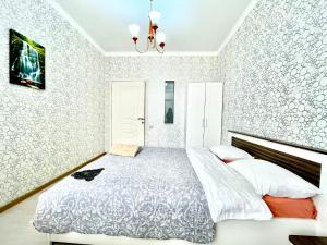 a bedroom with a bed and a chandelier at апартаменты с видом на город in Pavlodar