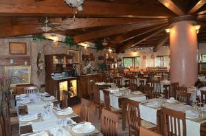 a dining room with white tables and chairs in a restaurant at Casa Vacanze VILLA SANDRINA in Costa Paradiso