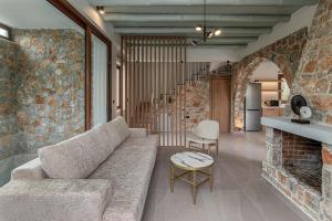 a living room with a couch and a brick wall at Villa Nineta in Tavronitis