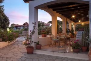 a patio with a table and chairs and flowers at Casa Vacanze VILLA SANDRINA in Costa Paradiso