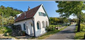 uma pequena casa branca com um telhado castanho em Vince Pince Ház em Balatongyörök