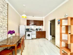 a kitchen and dining room with a table and appliances at апартаменты с видом на город in Pavlodar