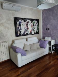 a living room with a white couch with purple pillows at Alba Langhe Apartment in Alba